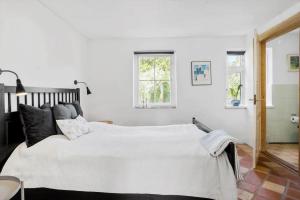 a bedroom with a large bed with white sheets at FY252-Haarby-Brunshusevej-23 in Hårby