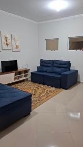 ラゴイーニャにあるCasa Do Solのリビングルーム(青いソファ、テレビ付)