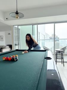 a woman playing pool in a room with a pool table at Inca inn apartments in Lima