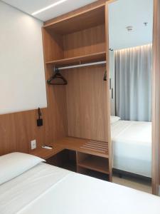 una piccola stanza con due letti e una scrivania di Apt 01 quarto Resort Salinas Premium a Salinópolis