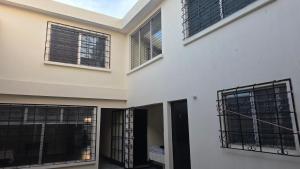 a white house with black barred windows at Be Happy Hotel in Guatemala