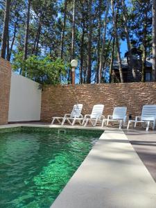 a group of chairs sitting next to a swimming pool at Le Cuyen Flat ll in Mar de las Pampas