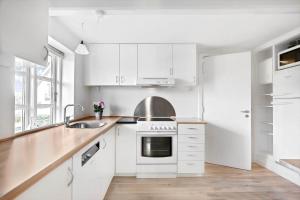 a white kitchen with white cabinets and a sink at FY344-Dalby-Fynshovedvej-344 in Dalby +14 photos