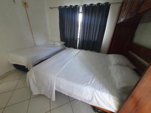 a bedroom with two beds and a window at Casa aconchegante em bairro privilegiado de Belém in Belém