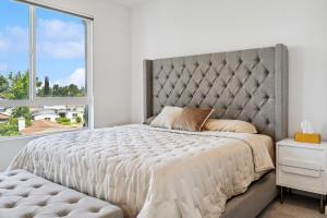 a bedroom with a large bed with a large window at NoHo Modern Townhouse with Gorgeous Rooftop in Van Nuys