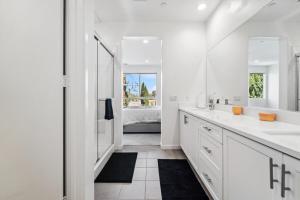 a white bathroom with two sinks and a shower at NoHo Modern Townhouse with Gorgeous Rooftop in Van Nuys +54 photos