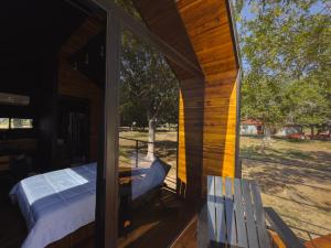 a porch of a house with a bed and a bench at Amazing cabin in Samalayuca in Samalayuca