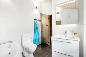 a white bathroom with a toilet and a sink at FY100-Asperup-Bogevangsvej-4 in Asperup +15 photos