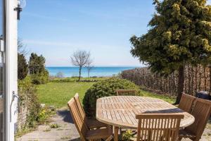 a wooden table and chairs with a view of the ocean at FY316-Hesselager-Syrenvej-8 in Hesselager +14 photos