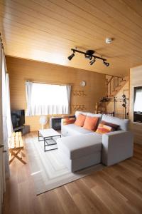 a living room with a white couch and a camera at LAKE TOYA PREMIUM CABIN in Lake Toya