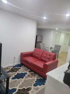 a red couch in a living room with a table at Entire Basement Suite in Bonavista in Winnipeg +19 photos