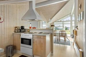a kitchen with a stove top oven next to a table at FY137-Middelfart-Altairvej-17 in Middelfart +14 photos