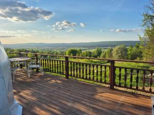 a wooden deck with a table and chairs on it at Glamping Agro Marzenie in Krajno Pierwsze
