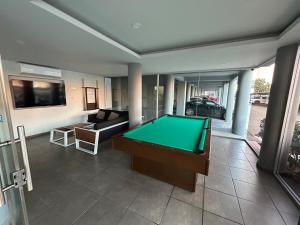Una sala de estar con una mesa de billar y un sofá. en Apartamento en Zona Playa Cerritos, en Mazatlán