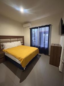 1 dormitorio con 1 cama con manta amarilla y ventana en Apartamento en Zona Playa Cerritos, en Mazatlán 11 fotos más