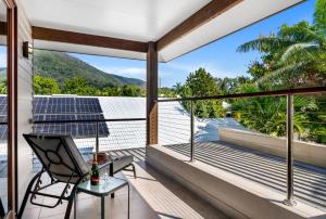 a room with a balcony with a chair and a table at Belle Escapes Sunset Boulevard in Palm Cove