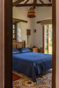 a bedroom with a bed with a blue comforter at Refugio Ecoturístico Villa Clarita in Estación El Salto