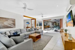 a living room with a couch and a table at Belle Escapes Sunset Boulevard in Palm Cove