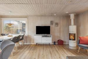 a living room with a television and a table and chairs at FY383-Bogense-Skastrup-Strand-Ost-23 in Bogense