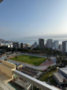 a view of a city with a park and the ocean at Inca inn apartments in Lima