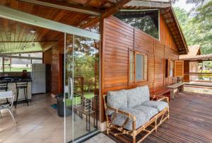 a screened in porch with a couch on a deck at Chalé Recanto da Paz in Itu