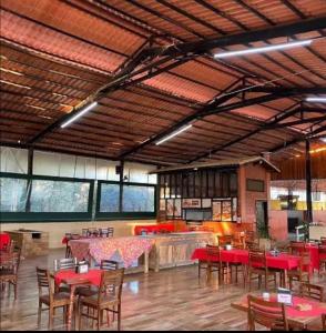 a dining room with tables and chairs in a building at Chalé Recanto da Paz in Itu