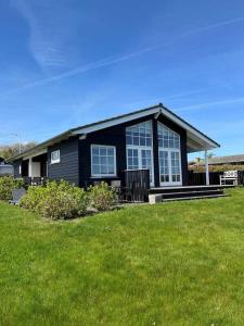 a black house with windows on a green lawn at FY384-Hesselager-Bellisvej-30 in Hesselager