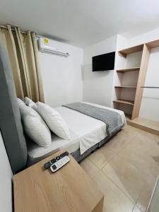 a bedroom with a bed and a table with a remote control at Edificio Las Vegas Apto privado a 15 min de Clínica Valle del Lili y Univalle a 5 min de Unicentro in Cali