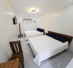 een slaapkamer met twee bedden en een televisie bij Leribi Suites and Restaurant in Ulot +23 foto's