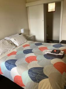 a large bed with a colorful blanket on it at Traveller's Haven in Millicent