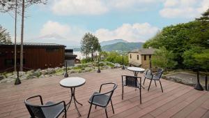 un patio con tavoli e sedie su una terrazza in legno di Kumonoue Fuji Hotel - Vacation STAY 13718v a Oishi