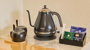 un bollitore per tè e una candela su un tavolo di Kumonoue Fuji Hotel - Vacation STAY 13703v a Oishi