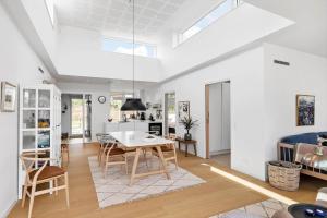 a kitchen and living room with a table and chairs at 5607-Svaneke-Mollebakken-8-P in Svaneke +14 photos