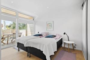a bedroom with a bed and a balcony with a table at 5607-Svaneke-Mollebakken-8-P in Svaneke
