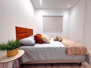 a bedroom with a bed with pillows on it at Apto com 1 quarto e sacada com churrasqueira in Brusque