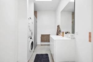 a white kitchen with a washing machine and a sink at 5607-Svaneke-Mollebakken-8-P in Svaneke