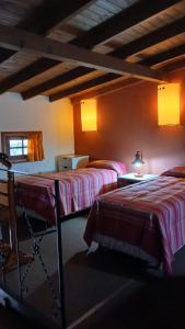 a room with two beds and a table with a lamp at Apart Don Ángel Tandil in Tandil