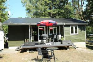 a house with a table and chairs and an umbrella at 6705-Hasle-Klympen-10 in Hasle