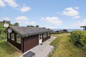 a small brown house with a pathway next to it at 6680-Allinge-Brunekulvej-2-C in Allinge +14 photos