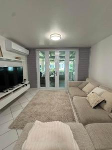 a living room with a couch and a flat screen tv at Villas de Playa II in Jayuya