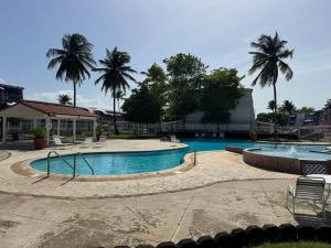 a large swimming pool with palm trees in the background at Villas de Playa II in Jayuya