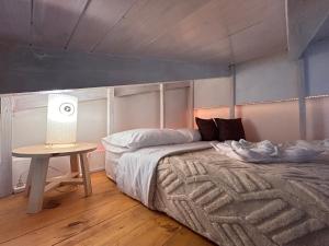 a bedroom with a bed and a table with a lamp at La Perla in El Bolsón