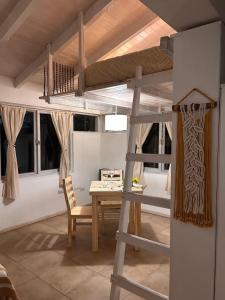 a loft bed in a room with a table and a ladder at La Perla in El Bolsón