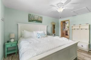 a large white bed in a bedroom with a ceiling fan at Karen's Sea-Foam Oasis in Bonita Springs