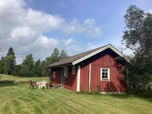 un granero rojo con una mesa y sillas en un campo en 4 person holiday home in TORUP, en Torup 18 fotos más