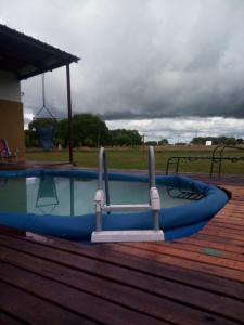 a swimming pool with a blue boat on a deck at El Atardecer in General Lavalle +17 photos