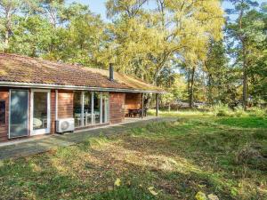 een houten huis met een veranda en een tuin bij 8 person holiday home in Frederiksværk in Frederiksværk