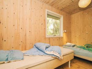 twee bedden in een houten kamer met een raam bij 8 person holiday home in Frederiksværk in Frederiksværk
