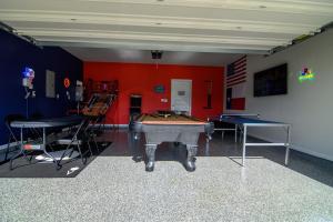 Habitación con mesa de ping pong y 2 mesas en Themed Game Room House 5 bedr near The Woodlands, en Magnolia