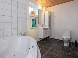 a bathroom with a white tub and a toilet at 6 person holiday home in Karrebæksminde in Karrebæksminde +48 photos